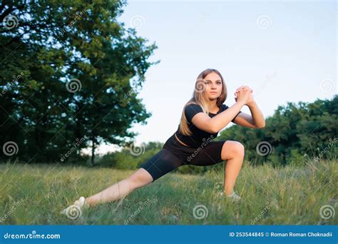 Athletic Girl Blonde In The Park At Sunset Performs Sports Exercises Squats Stock Image Image
