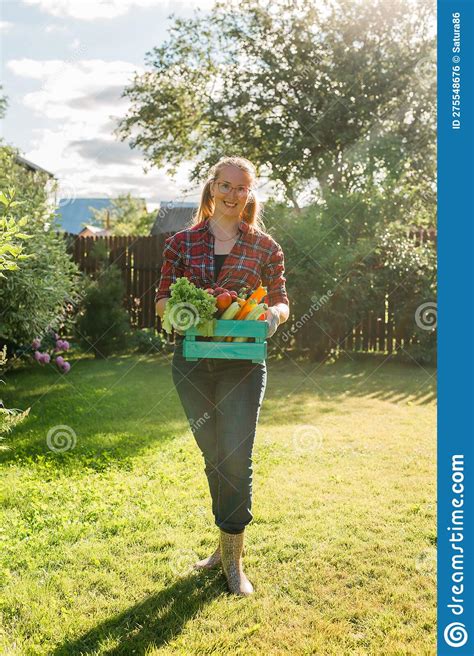 Female Farmer Carrying Box Of Picked Vegetables Garden And Harvesting