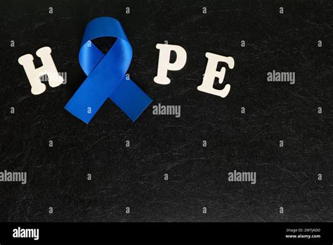 Dark blue ribbon color isolated on dark black background. Colon and colorectal cancer awareness ...