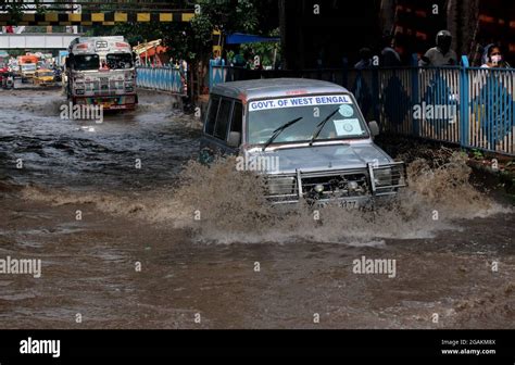 Commuters Wade Through A Waterlogged Street In Floodwaters Following