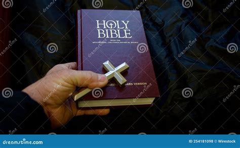 Holy Bible With Hard Holding Silver Cross Crucifix Black Background