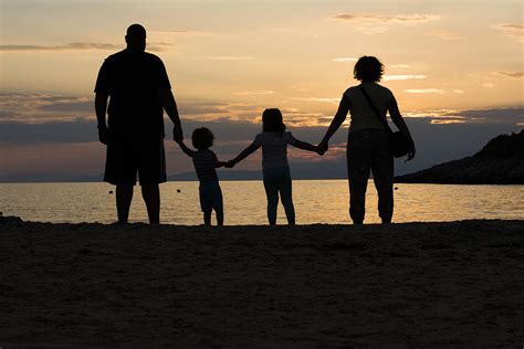 Family on a beach holding hands at sunset Photograph by Newnow ...