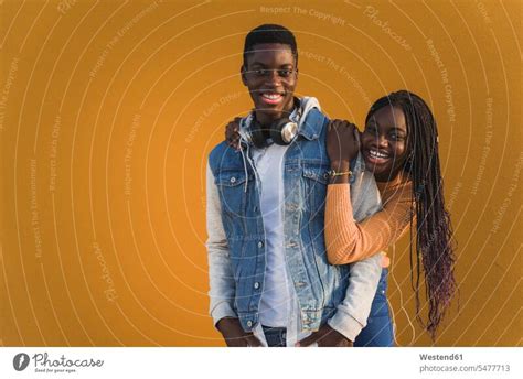 Happy Heterosexual Couple Against Yellow Wall A Royalty Free Stock