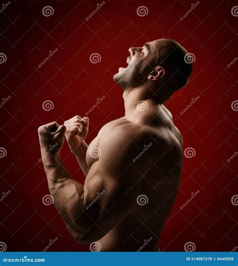 Screaming Strong Muscular Man Bodybuilder Stands With Naked Chest Shirtless Holding Up His