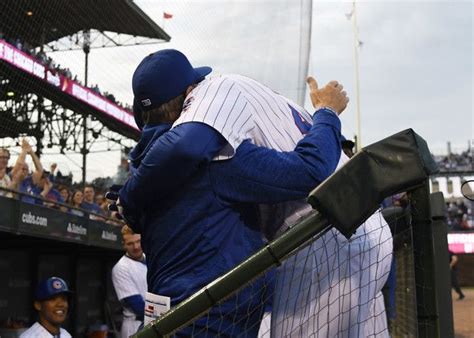 Two Baseball Players Hugging Each Other In The Dugout