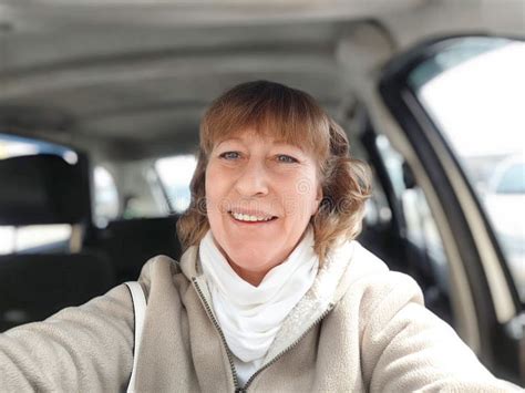 Middle Aged Woman In A Car Taking Selfie While Enjoying A Drive Female Mature Driver Posing