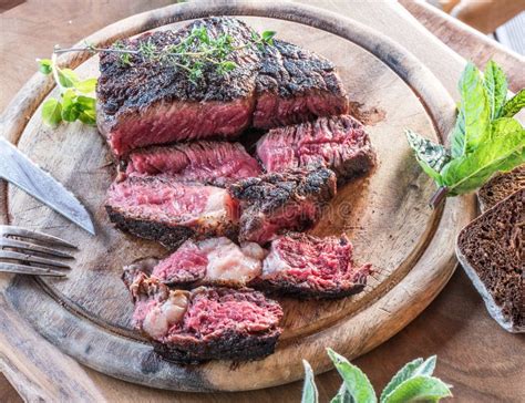 Medium Rare Ribeye Steak with Herbs on Graphite Board Stock Photo - Image of meal, peppercorn ...