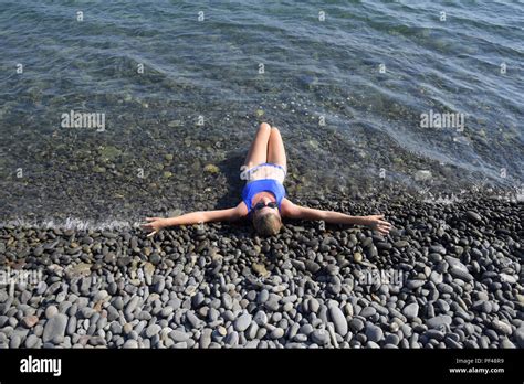 Une Belle Fille Dans Un Bikini Bleu Se Trouve La Moitié Dans Leau Sur