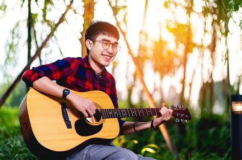 Guitarra y hombre el joven guitarrista toca alegremente la música