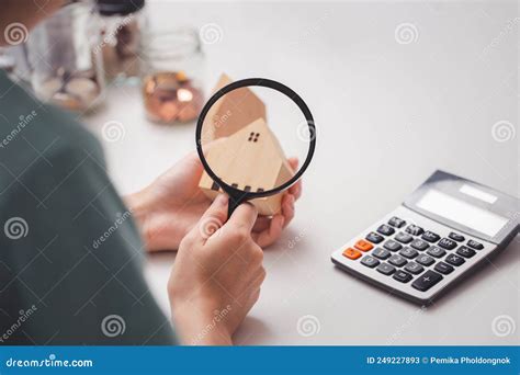 Woman S Hand Holding A Magnifying Glass Looks At A Model Of A Wooden