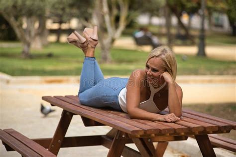 Mature Woman Beautiful Blonde With White Top And Jeans In A Funny Flirtatious And Sensual