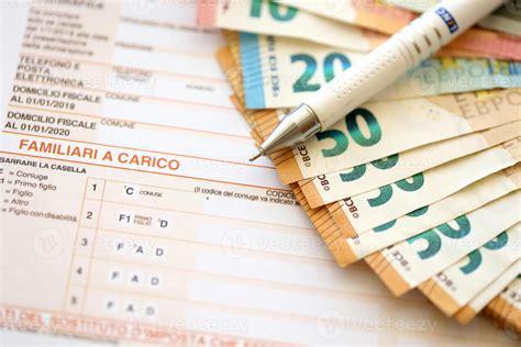Filling italian tax form process with pen and euro money bills close up