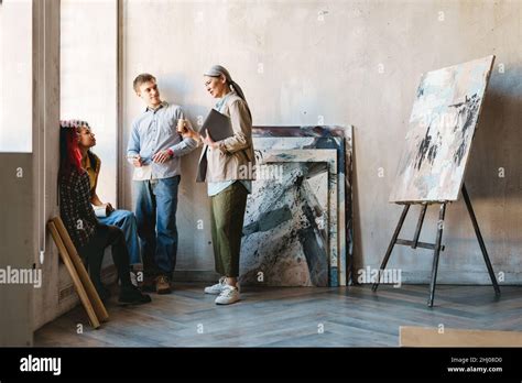 Enseignante mature parlant avec ses élèves pendant la classe à l intérieur de l école d art