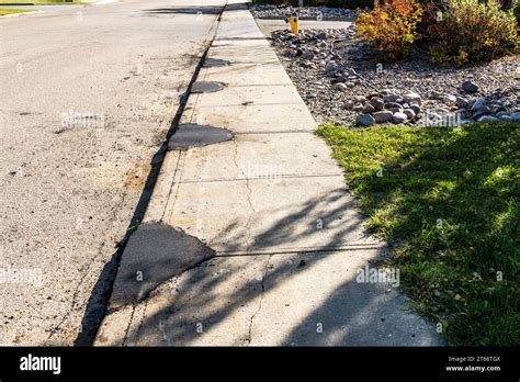 Concrete Sidewalk Repair With Multiple Asphalt Patching Stock Photo Alamy