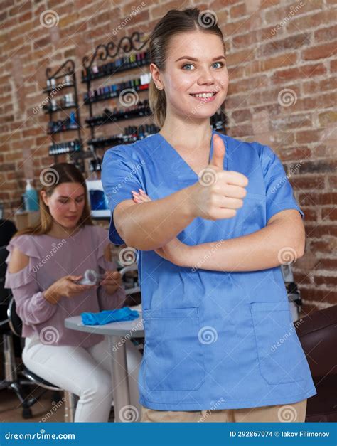 Young Smiling Girl Manicurist Standing In Modern Nail Salon Stock Photo