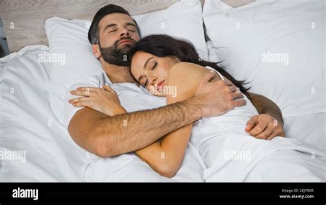 young couple hugging while sleeping on white bedding Stock Photo - Alamy