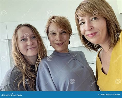 Beautiful Mature Mother And Her Daughter Making A Selfie Using Smart Phone And Smiling Indoor