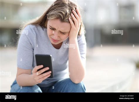 Sad Teen Checking Bad News On Mobile Phone Complaining Alone In The