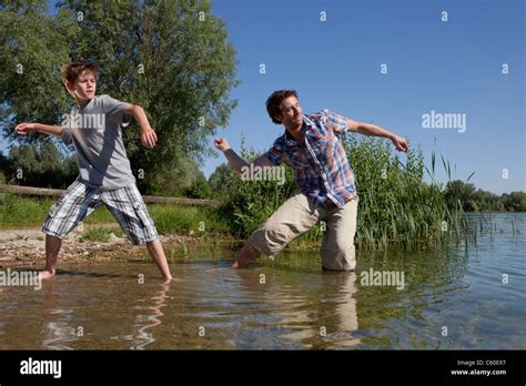 Father and son skipping rocks on lake Stock Photo - Alamy