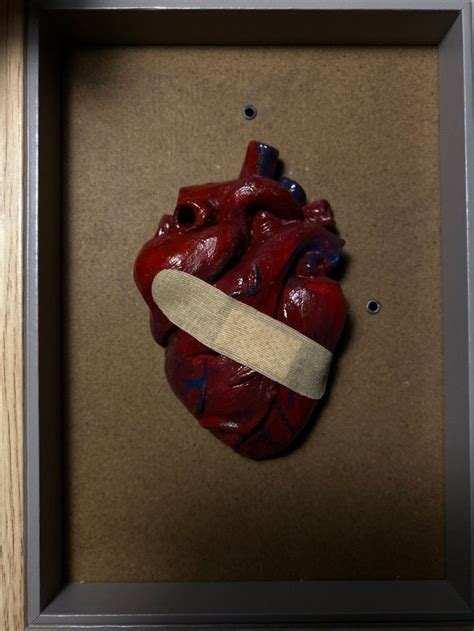 A Heart In A Shadow Box With A Piece Of Paper Taped To It S Side