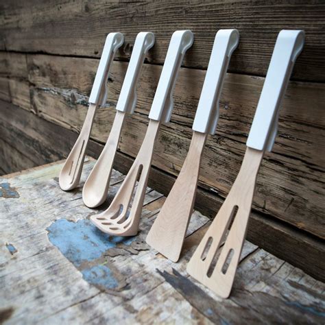 Five Wooden Spatulas Are Lined Up Against A Wood Planked Wall With