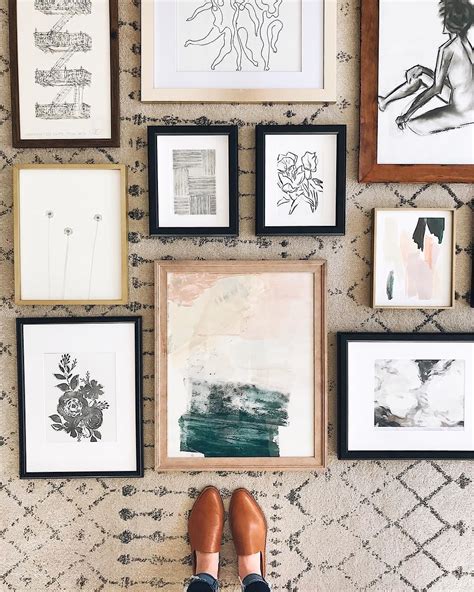 A Person Standing In Front Of Many Framed Pictures