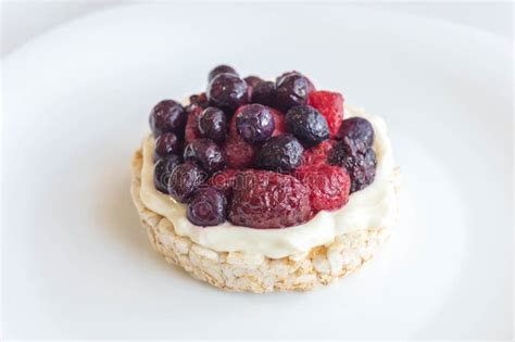 Galleta De Arroz Con Crema Y Fruta Roja En El Plato Imagen De Archivo