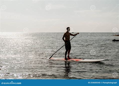 Side View Foto Of A Man Swiming And Relaxing On The Sup Board Sportive