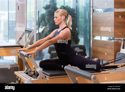Active Blonde Woman Strengthening Abdominal And Leg Muscles On Reformer Stock Photo Alamy