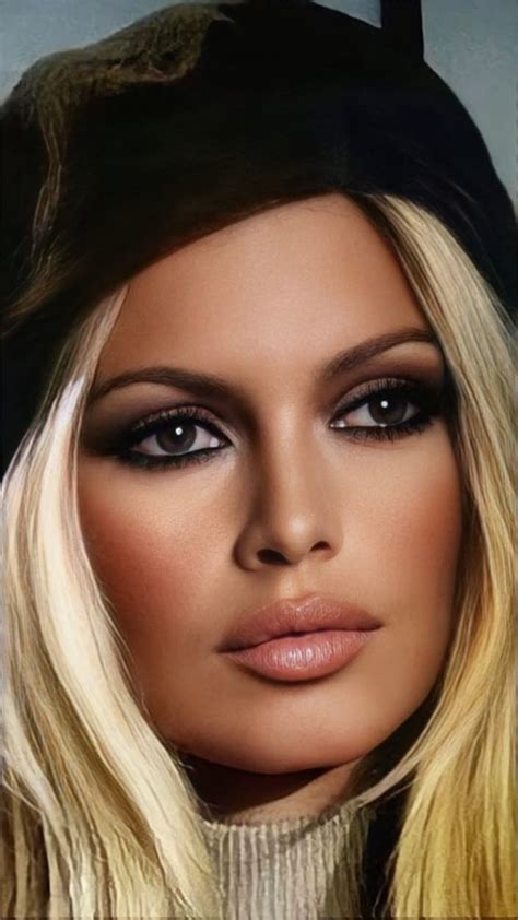 A Woman With Long Blonde Hair Wearing A Black Hat And Eye Shadow On Her Face