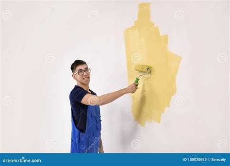 Pared Masculina De La Pintura Del Decorador Con El Rodillo Dentro