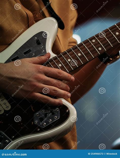 Hands Of A Man Holding An Electric Guitar During A Performance Stock