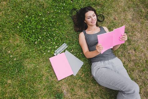 Free Photo | Girl lying on grass reading notebook