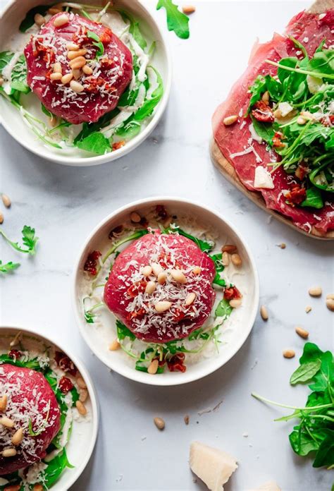 Three White Bowls Filled With Food And Garnished With Green Leafy Toppings