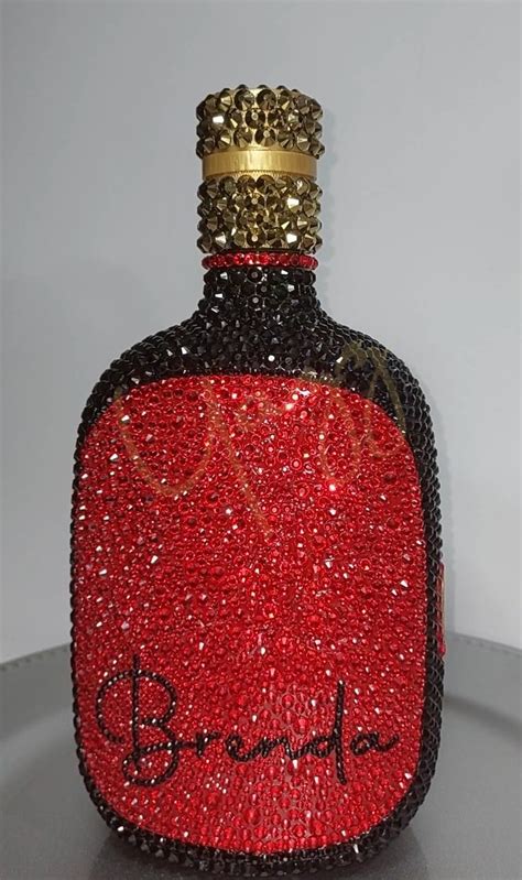 A Red And Black Bottle With A Crown On Top