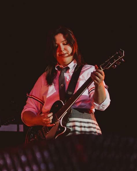 a woman playing an electric guitar on stage