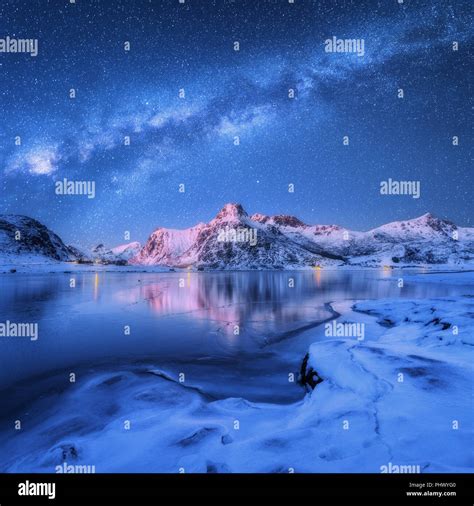 Milky Way above frozen sea coast and snow covered mountains in winter ...