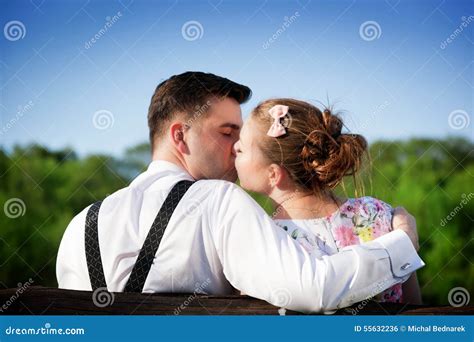 Young Couple In Love Kissing On A Bench In Summer Park Stock Photo