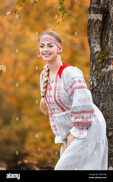 Young Attractive Woman Smiles In Folk Traditional Slavic Dress Near