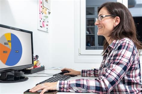 Premium Photo Smiling Mature Woman With Glasses Looking At A Computer