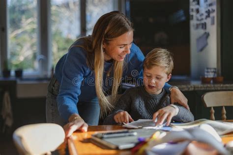 Madre Ayudando A Su Hijo Con Los Deberes Foto De Archivo Imagen De