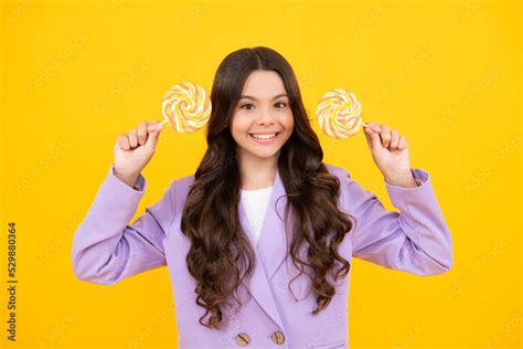 Funny child with lollipop over yellow isolated background. Sweet ...