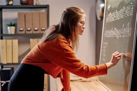 Premium Photo Female Music Teacher Writing On Chalkboard