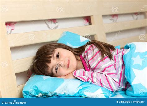 Little Girl In Pajamas Sleep In Bed Under A Blue Blanket Stock ...