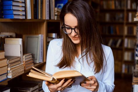 Joven Estudiante Mirando Libros En La Biblioteca En Busca De La