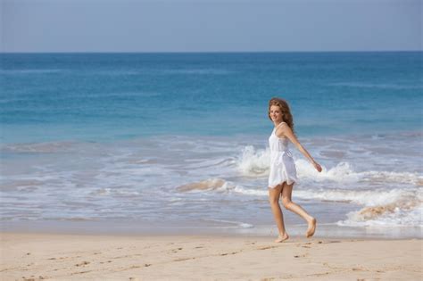 Retrato de jovem de biquíni branco na praia tropical olhando para a câmera linda garota latina