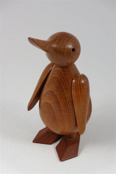 A Small Wooden Bird Sitting On Top Of A White Table