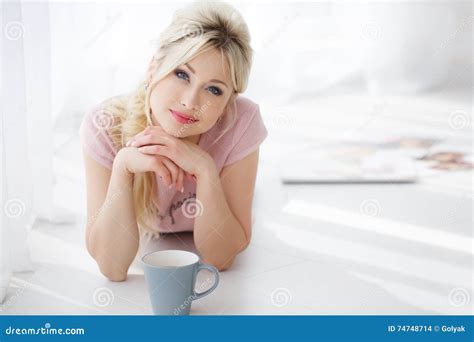 Belle Femme Se Trouvant Sur Un Plancher Blanc Avec Une Tasse De Th