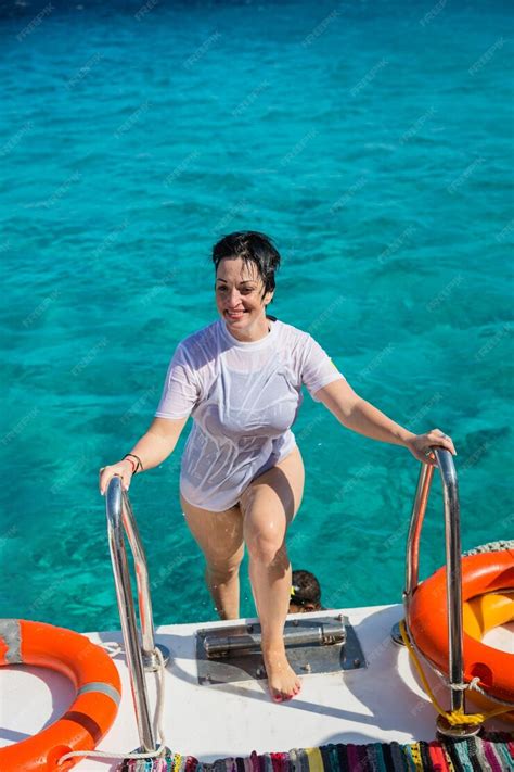 Premium Photo | Happy woman in a wet tshirt climbs stairs on board a ...