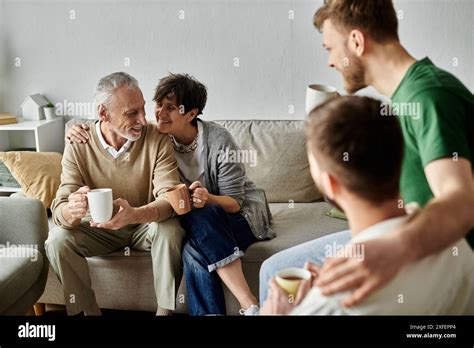 A Gay Couple Sits On A Couch With Parents Sharing A Warm Moment Together Stock Photo Alamy